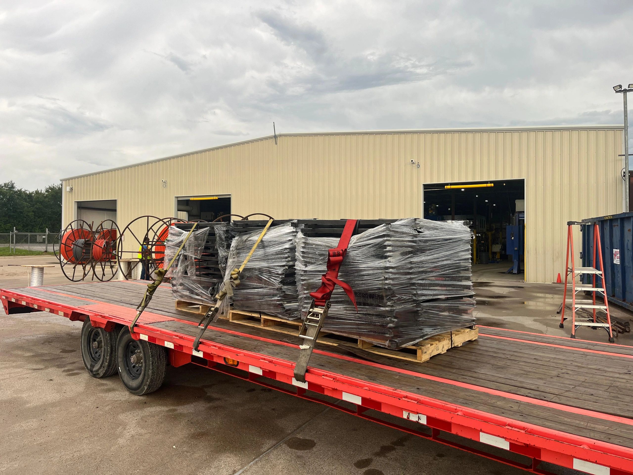 Red flatbed trailer wrapped pallets warehouse