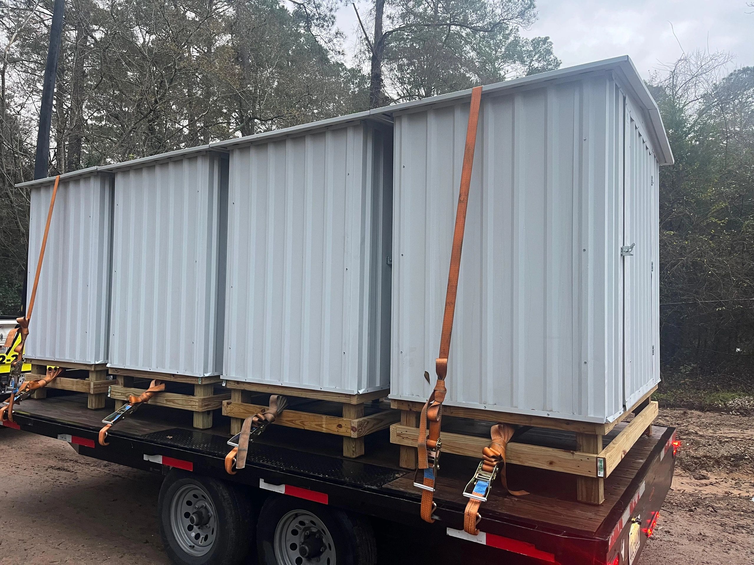 Modular building transported flatbed trailer wooded area