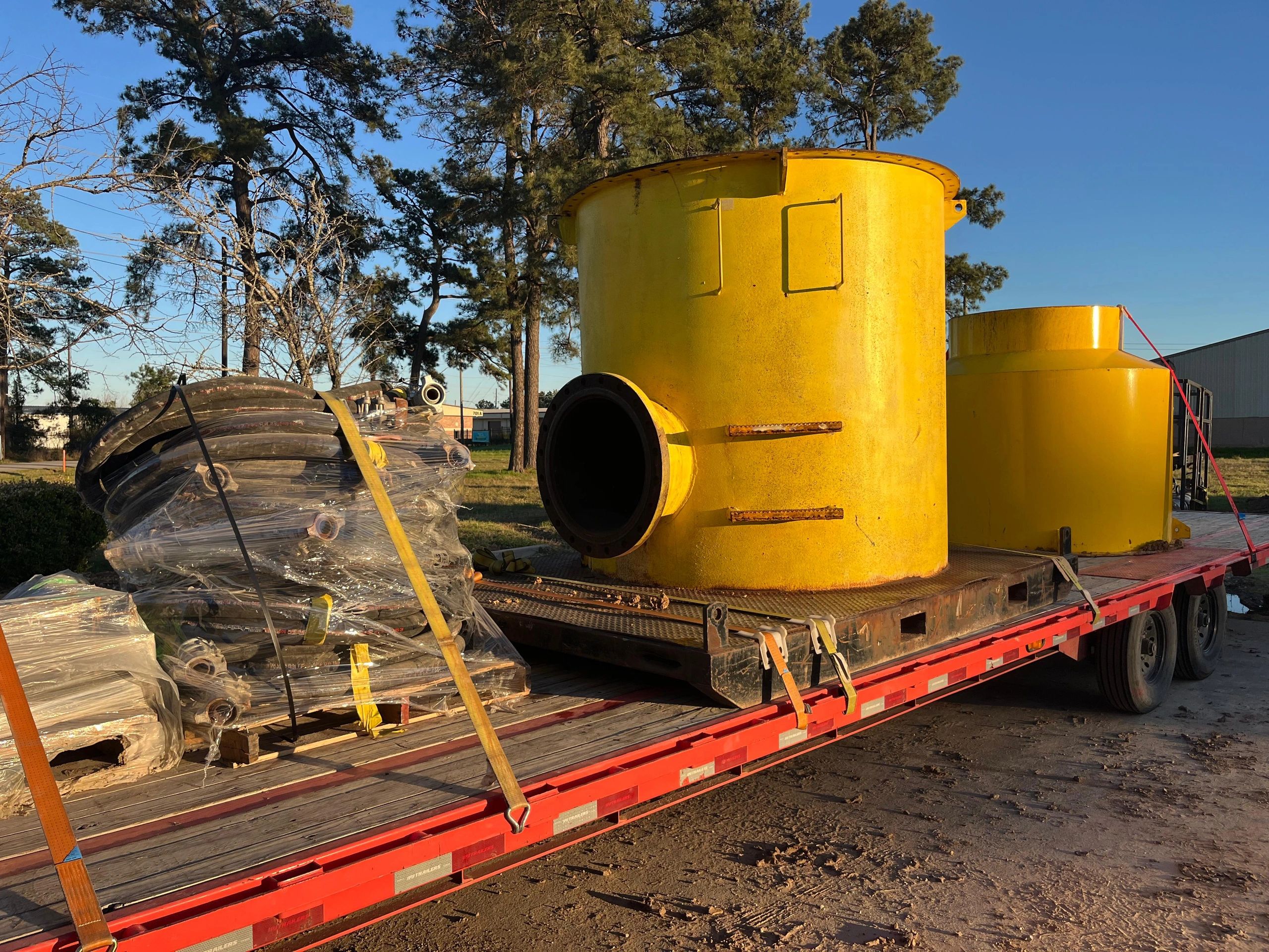 Yellow pressure vessel tank red flatbed trailer